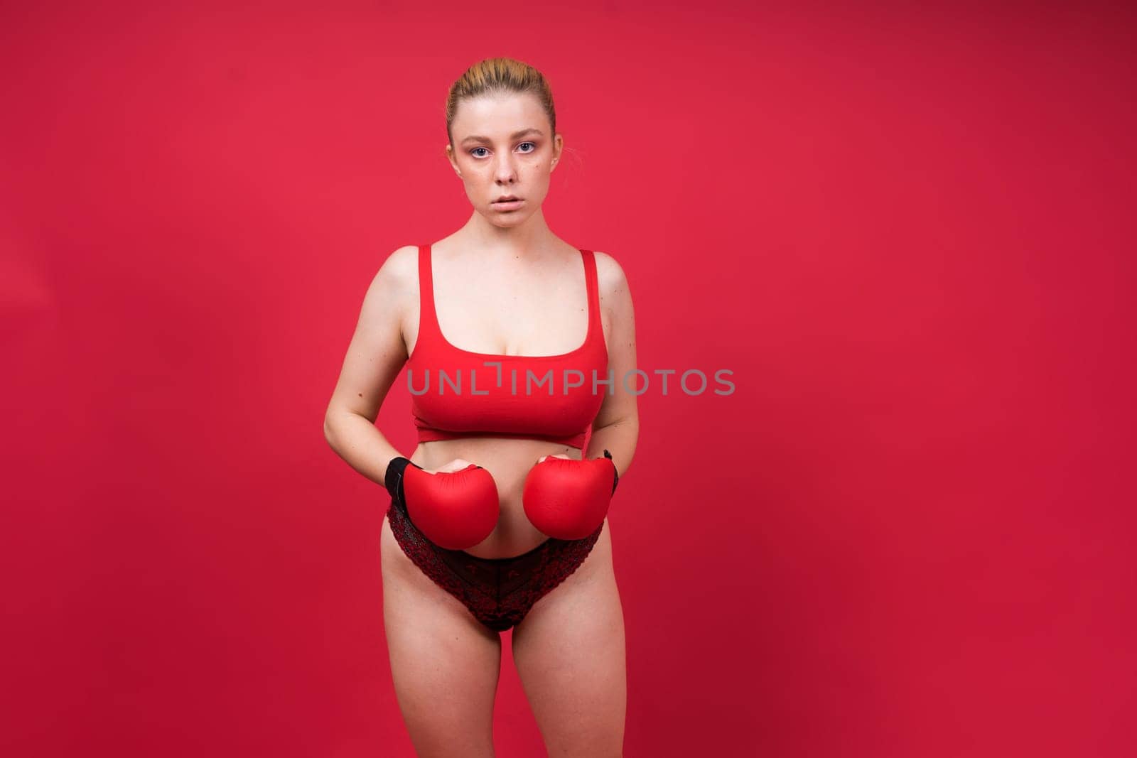A beautiful, attractive, seductive girl with blonde hair in a studio.