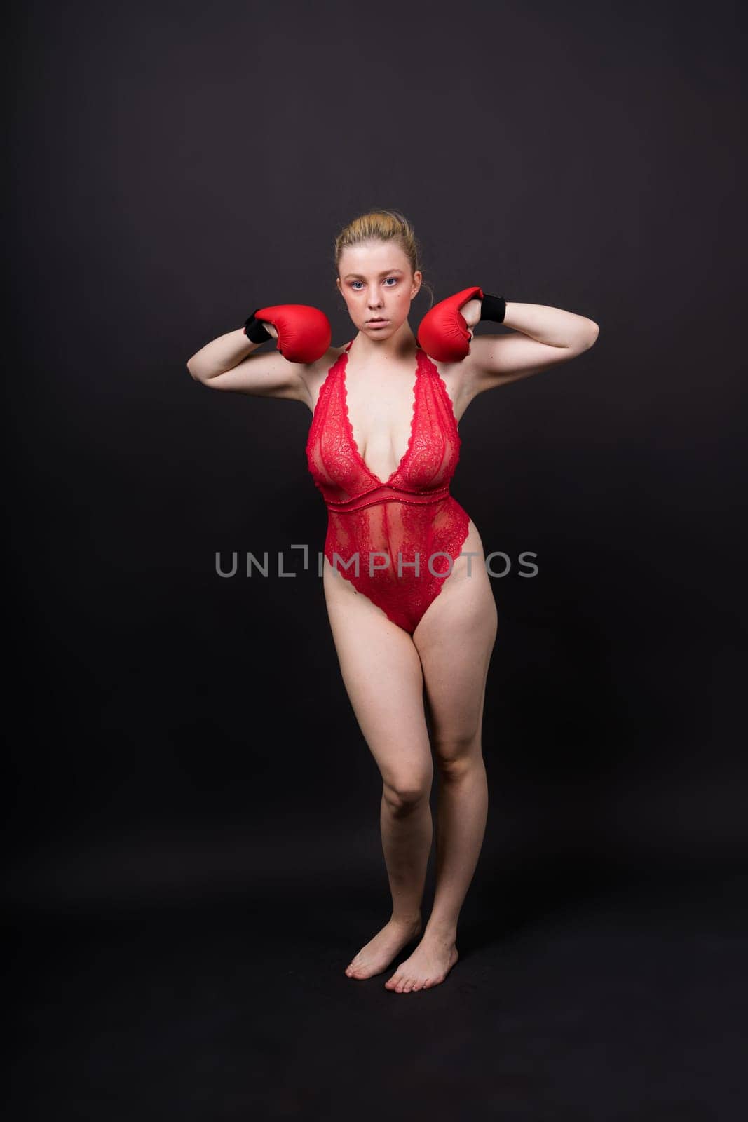 A beautiful, attractive, seductive girl with blonde hair in a studio.