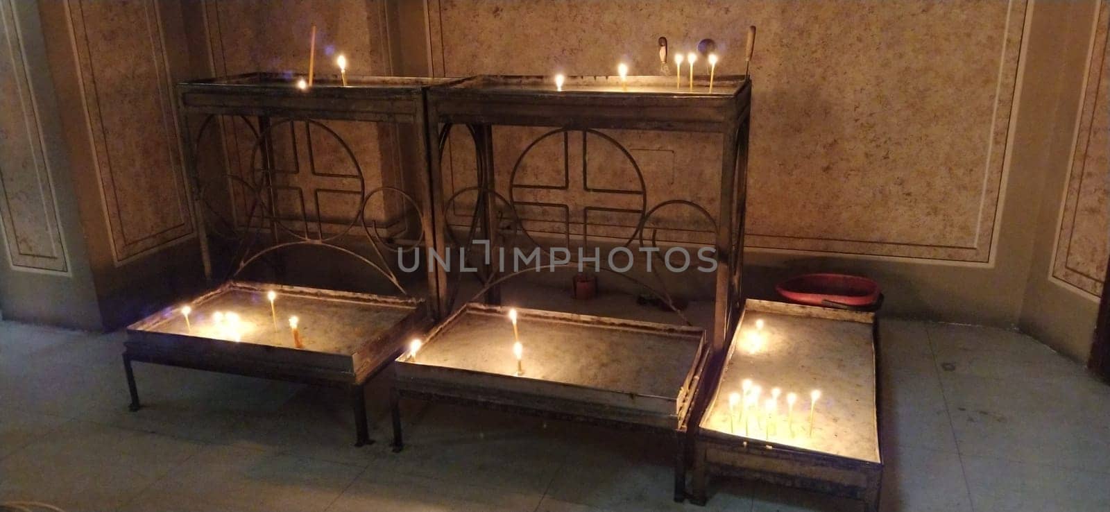 burning candles in the church on metal tables. Ignited symbols of the memory of the departed.