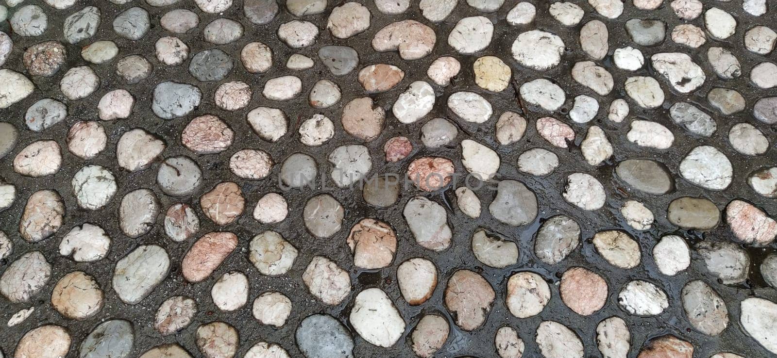 Paving stones made of round light stones similar to marble. Paved square in the old town of Sarajevo, Bosnia and Herzegovina. Beautiful wet shiny stones after rain. Close-up in natural daylight.
