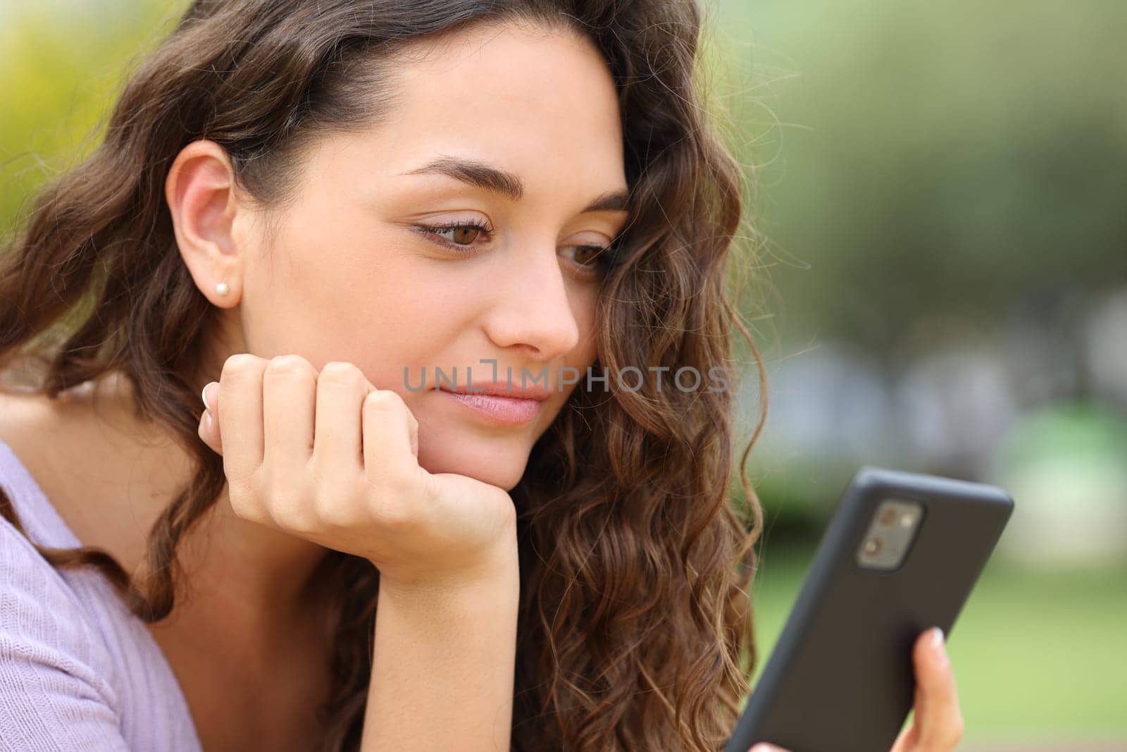 Woman using smart phone outside in a park