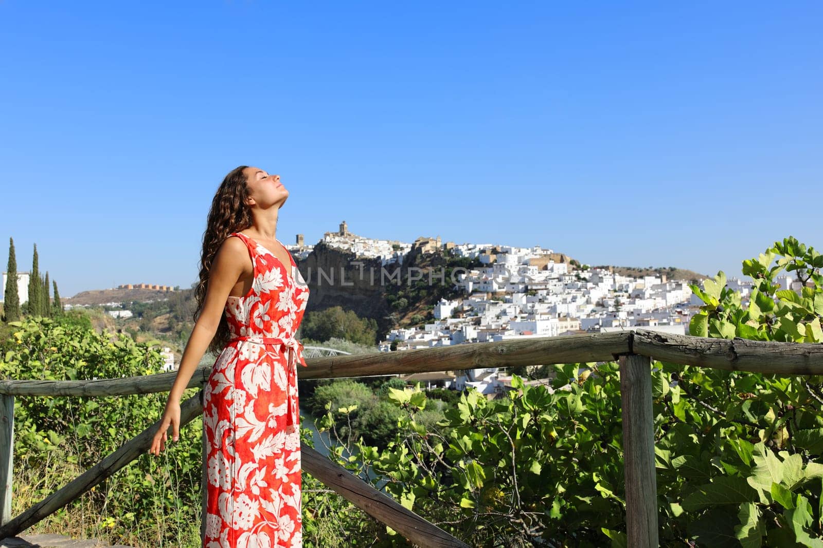 Profile of a tourist relaxing breathing fresh air on summer vacation in a town outskirts