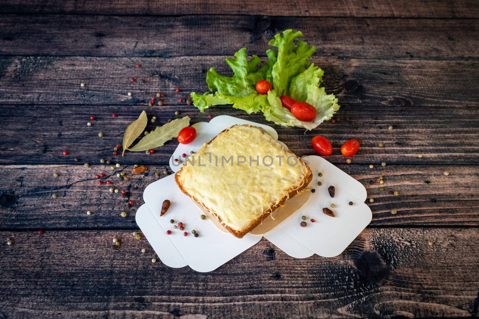 grilled croque monsieur with melted cheese served on a wooden base