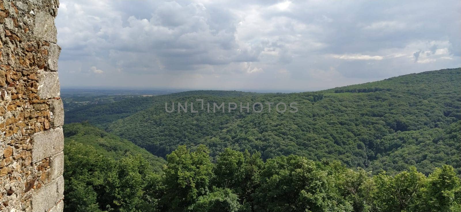 Ruins of an old fortress in Vrdnik, Sremska Mitrovica, Vojvodina, Serbia. Ancient stone walls with mountain ranges in the background. Tourist historical sights. Edge of the wall.