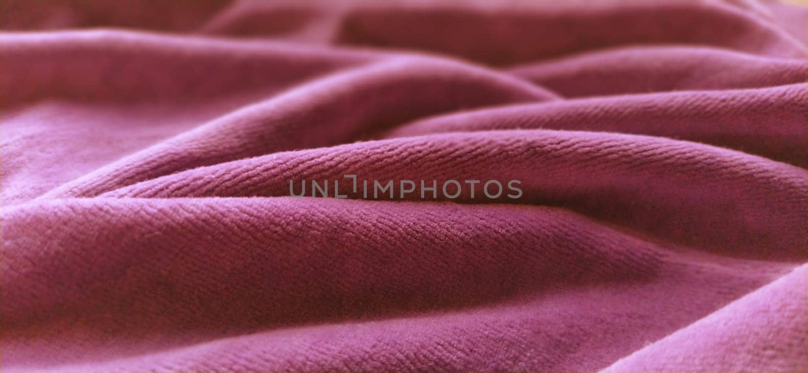 Pink velvet is folded by beautiful waves. Retro style. Soft pleasant fabric for sewing clothes, items for the interior, for upholstery. Soft focus.