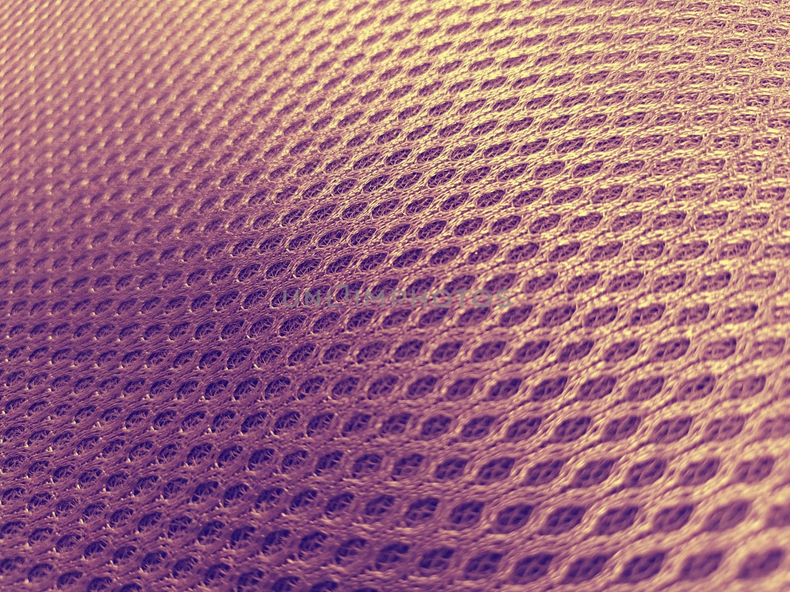 Pink synthetic porous material with a gradient in purple and yellow. Close-up tilted. Polyester fabric. Fabric for sewing clothes, upholstery and furniture