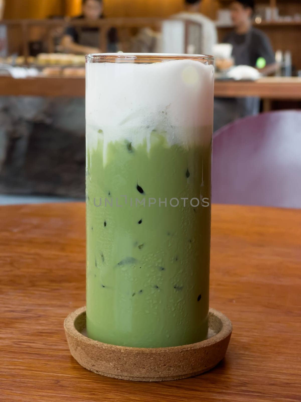 Iced matcha greentea on wooden table in coffee shop, stock photo