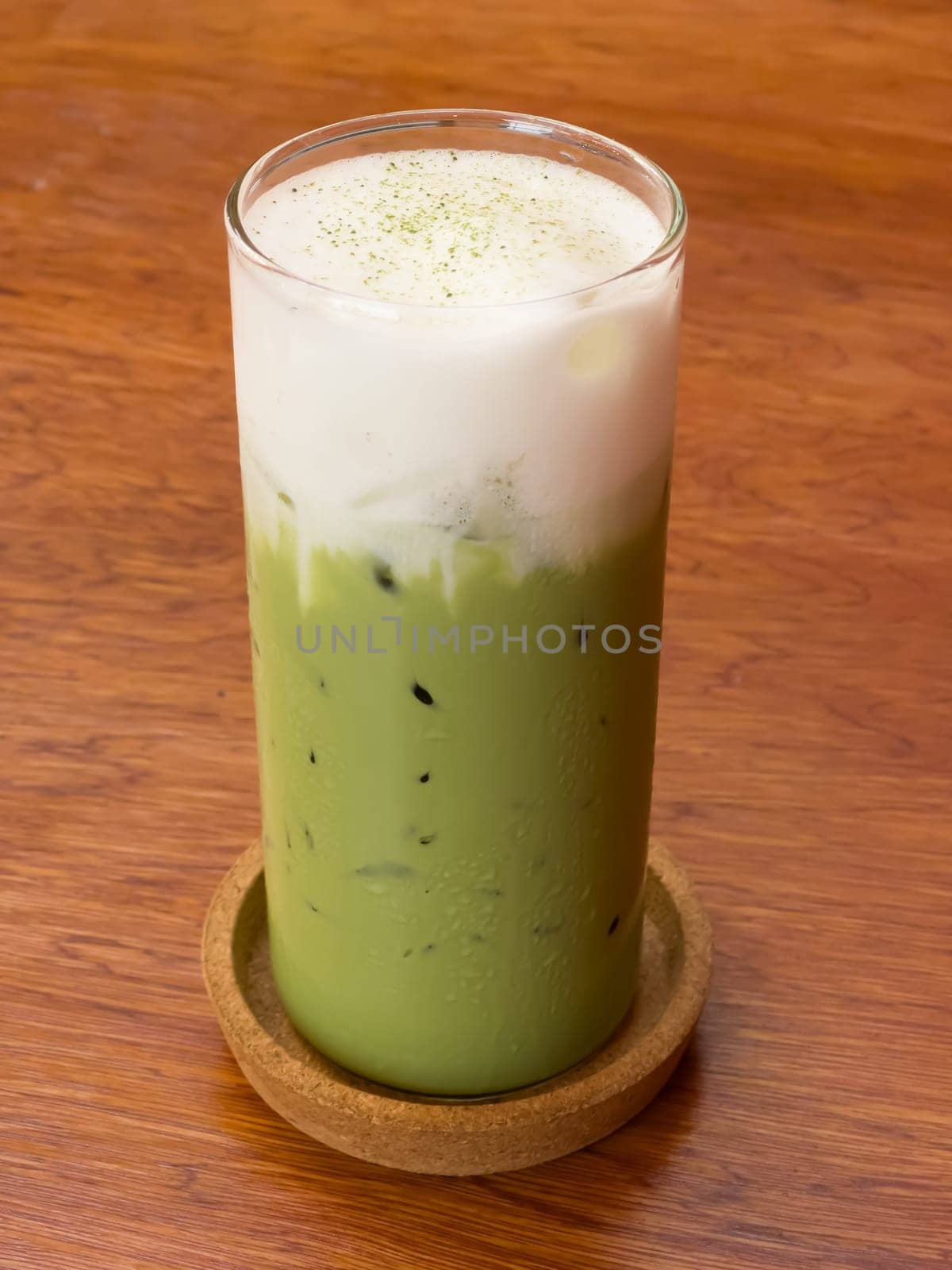 Iced matcha greentea on wooden table in coffee shop, stock photo