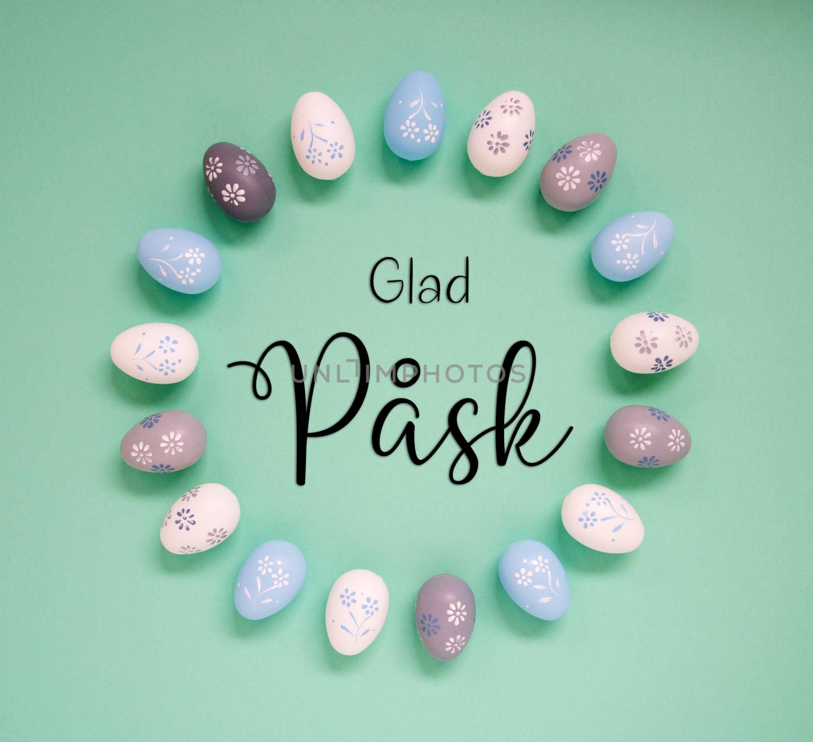 Flat Lay With Swedish Text Glad Pask Means Happy Easter. Easter Egg Arrangement, Decoration And Ornament. Light Green Paper Background