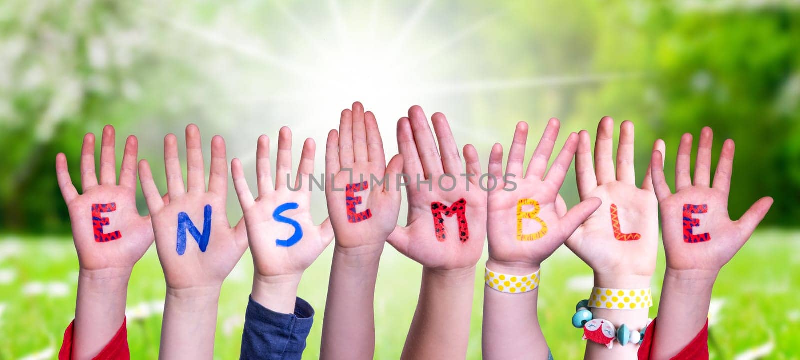 Children Hands Building Colorful English Word Ensemble. Sunny Green Grass Meadow As Background.