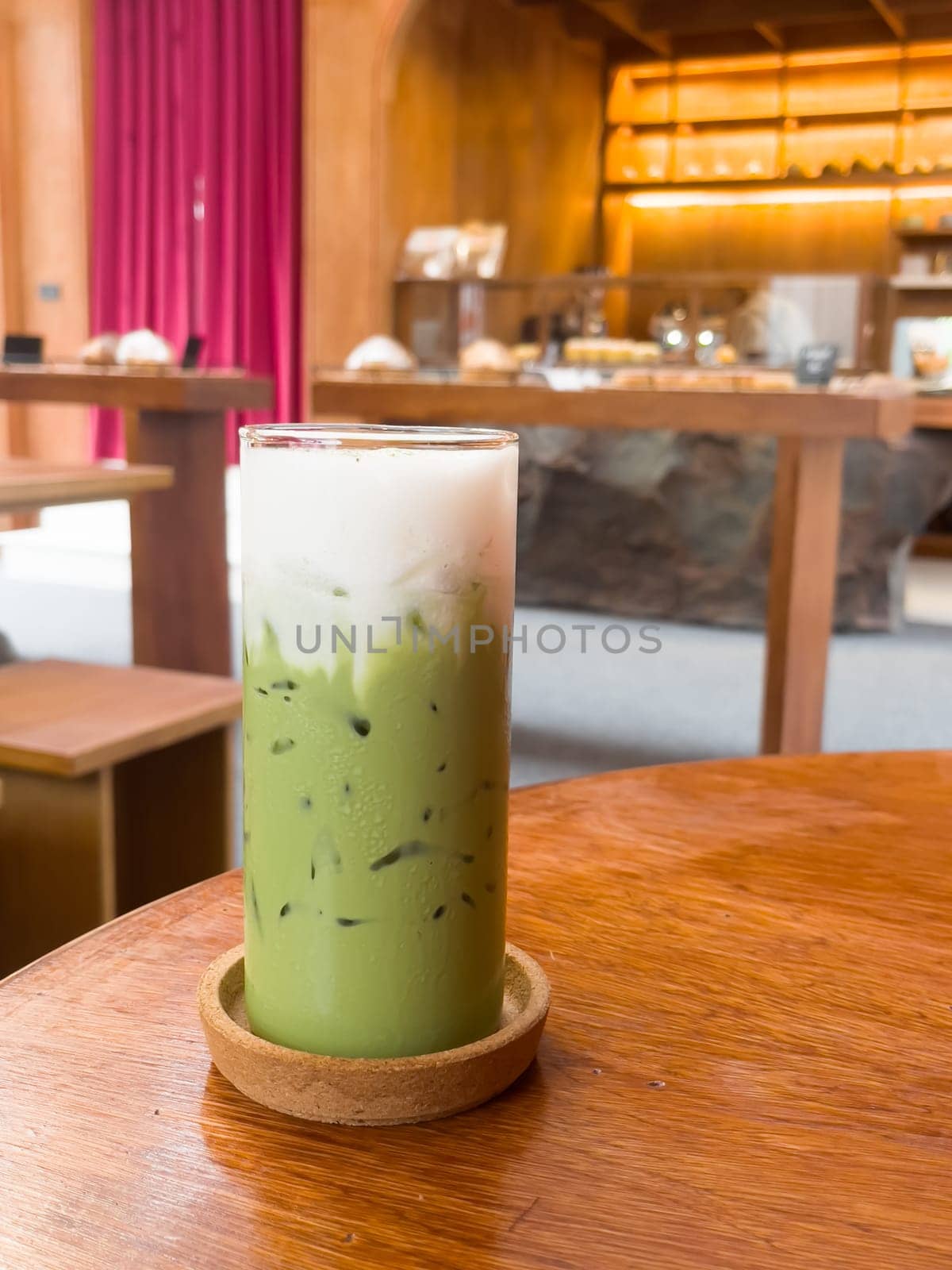 Iced matcha greentea on wooden table in coffee shop, stock photo