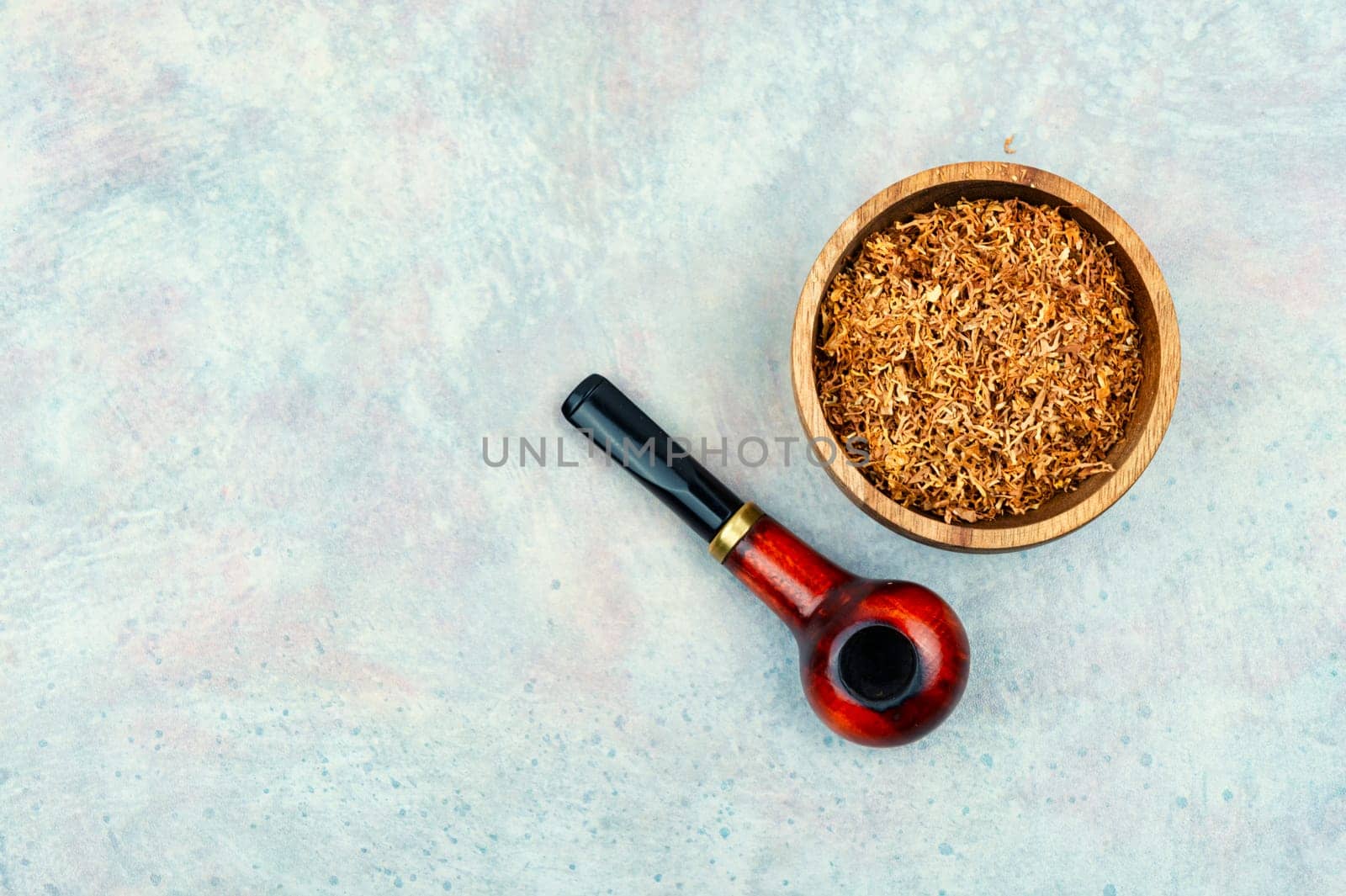Smoking tobacco and classic wooden smoking pipe on the table for man