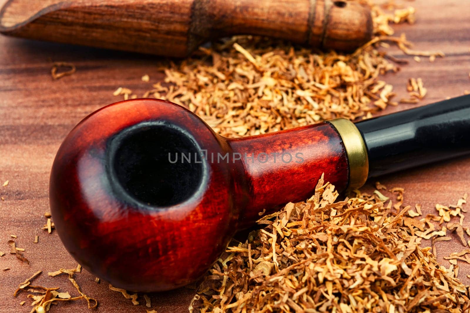 Fragrant smoking tobacco and a smoking tube or pipe on the table.