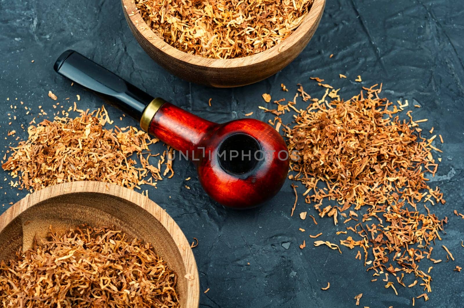 Fragrant smoking tobacco and a smoking tube or pipe on the table.