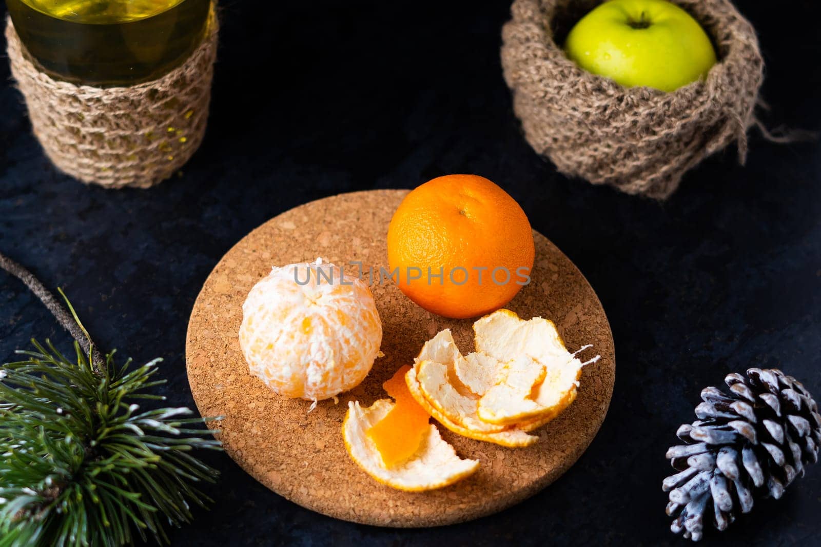 New Year's Christmas still life branch of pine tree next to tangerine cones on black background