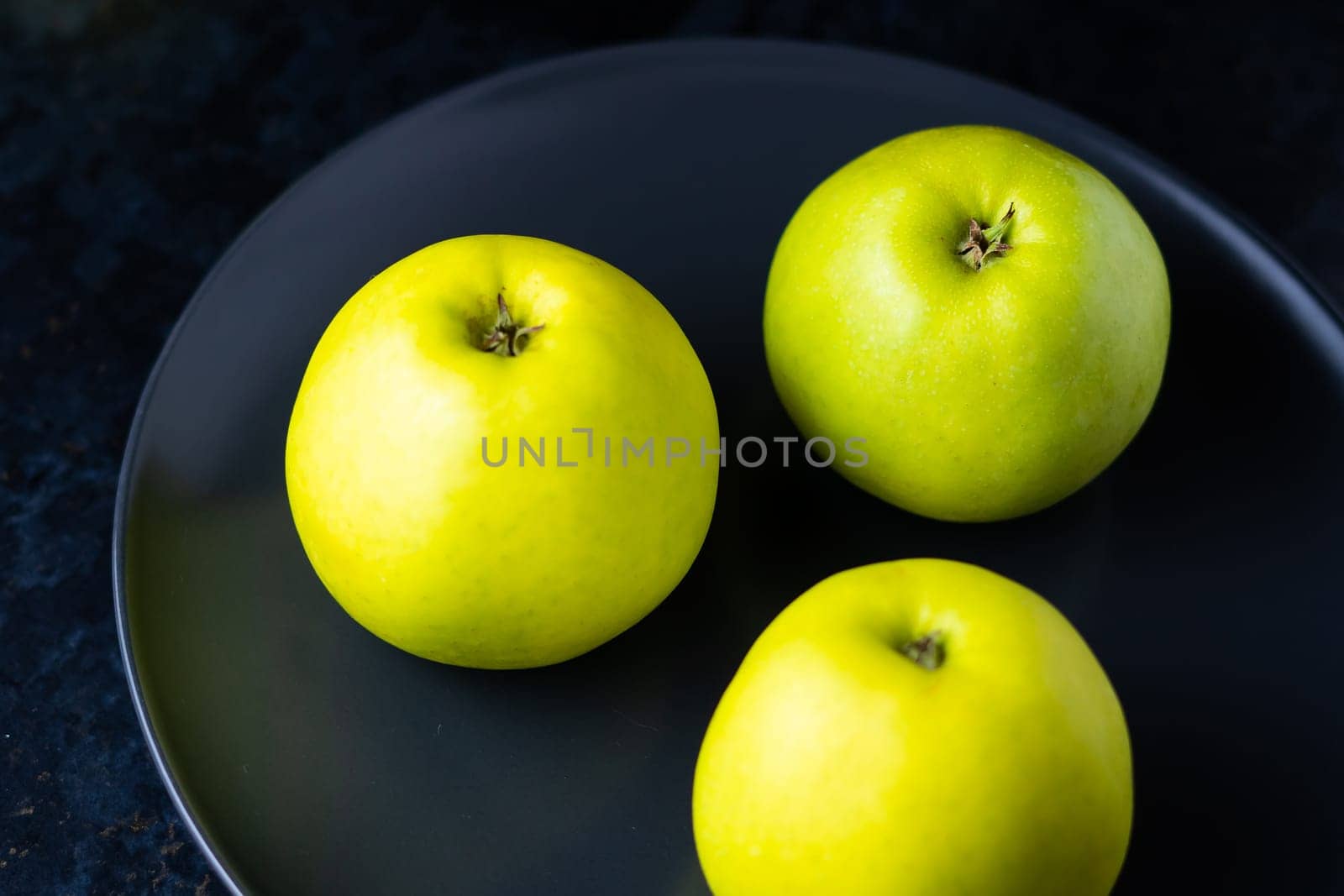 Ripe green apple fruits on a dark stone table. Top view with copy space. Flat lay