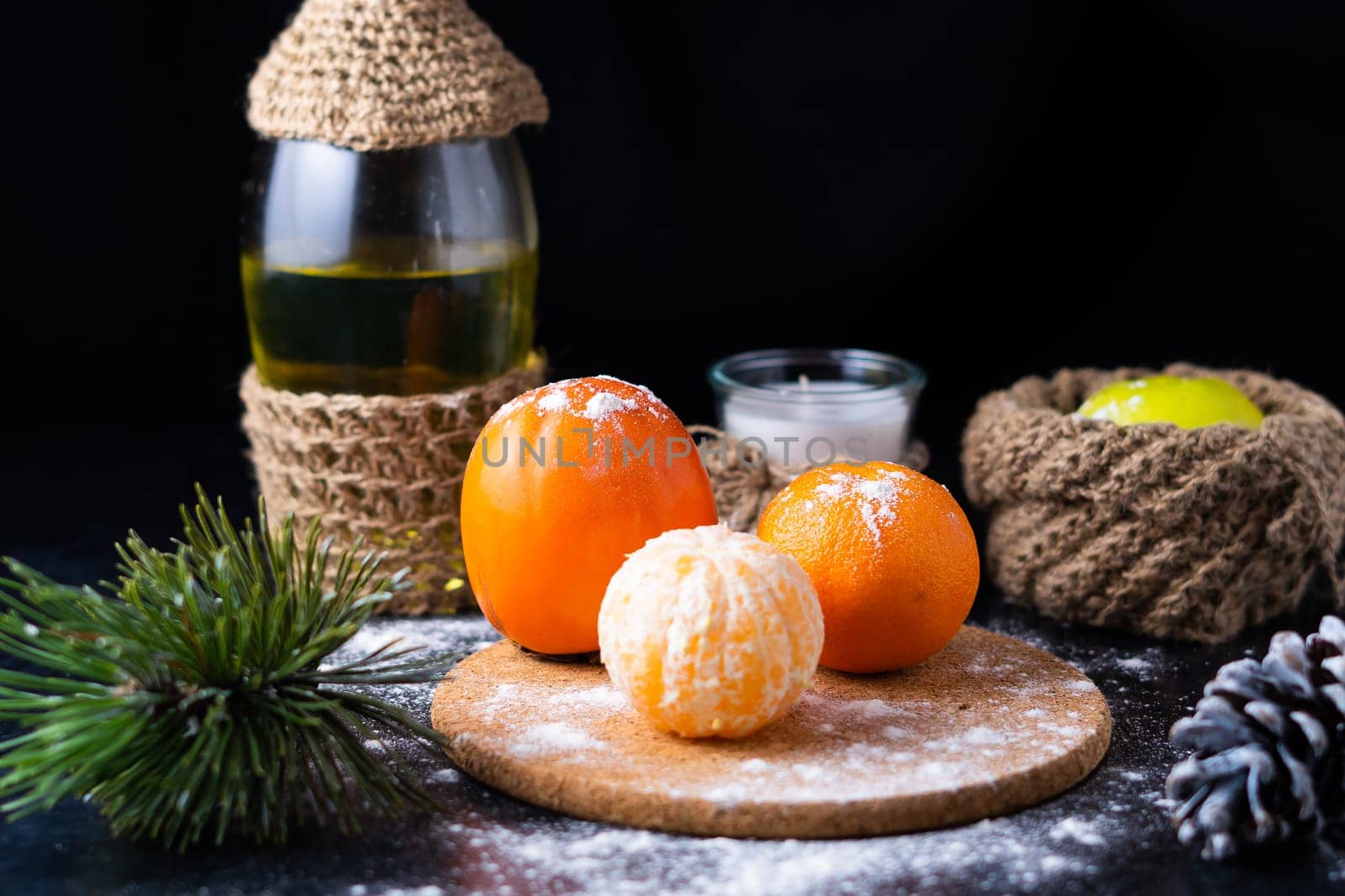 New Year's Christmas still life branch of pine tree next to tangerine cones on black background