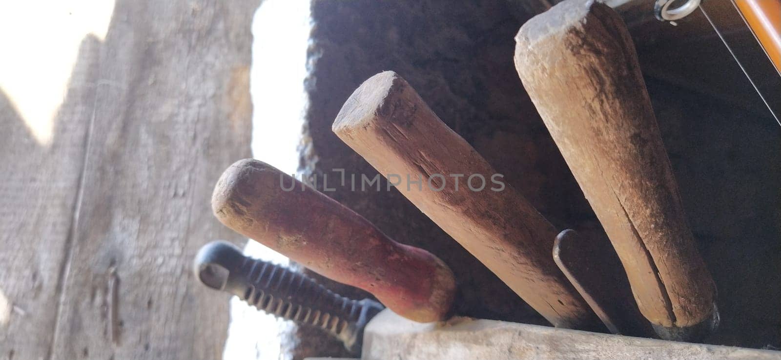 old farming tools at walls of the house. barn tool handles.