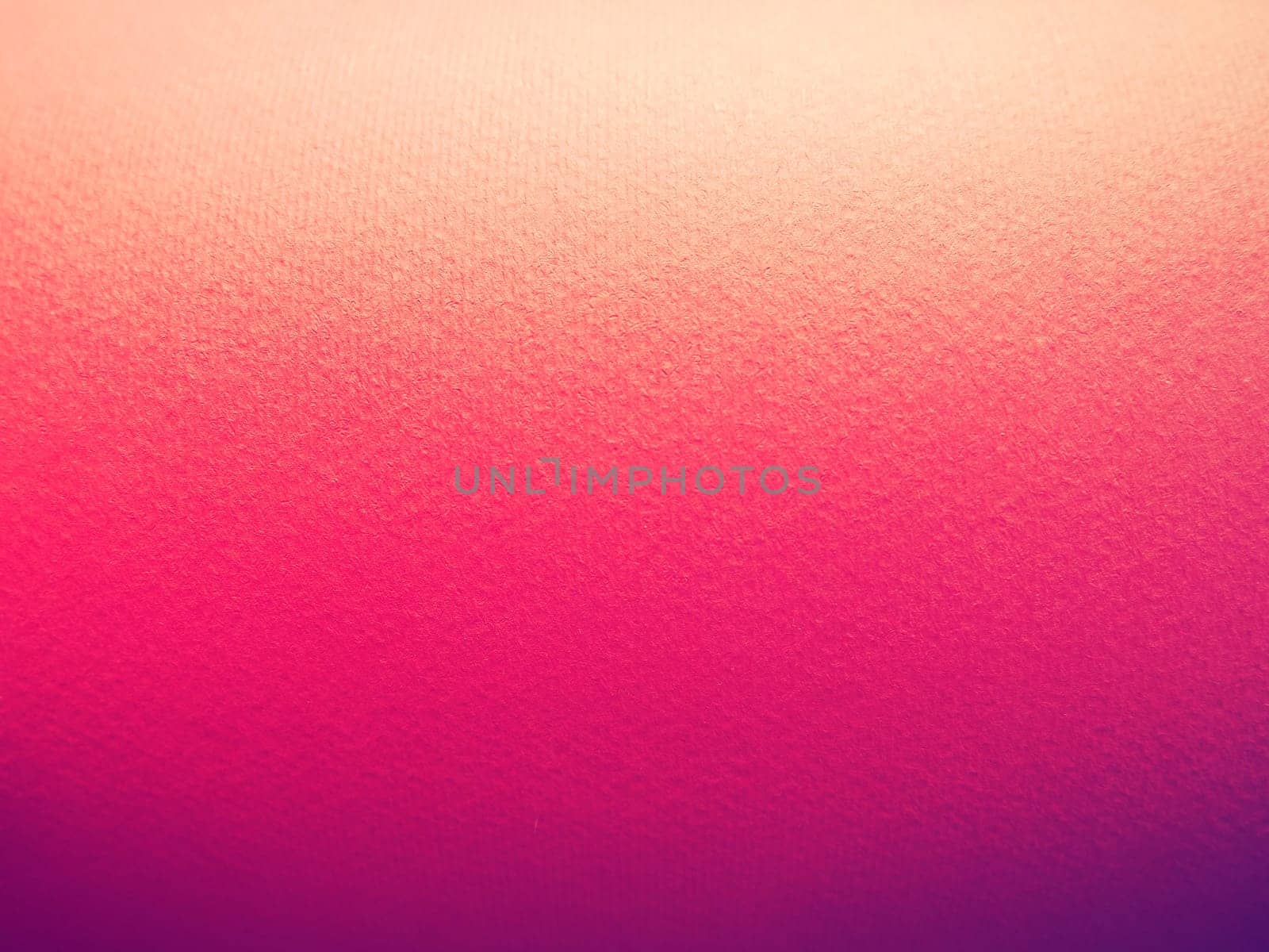 Abstract pink and purple background with texture. Close-up of paper surface with light and color gradient. Side lighting. Vivid purple or magenta shade.