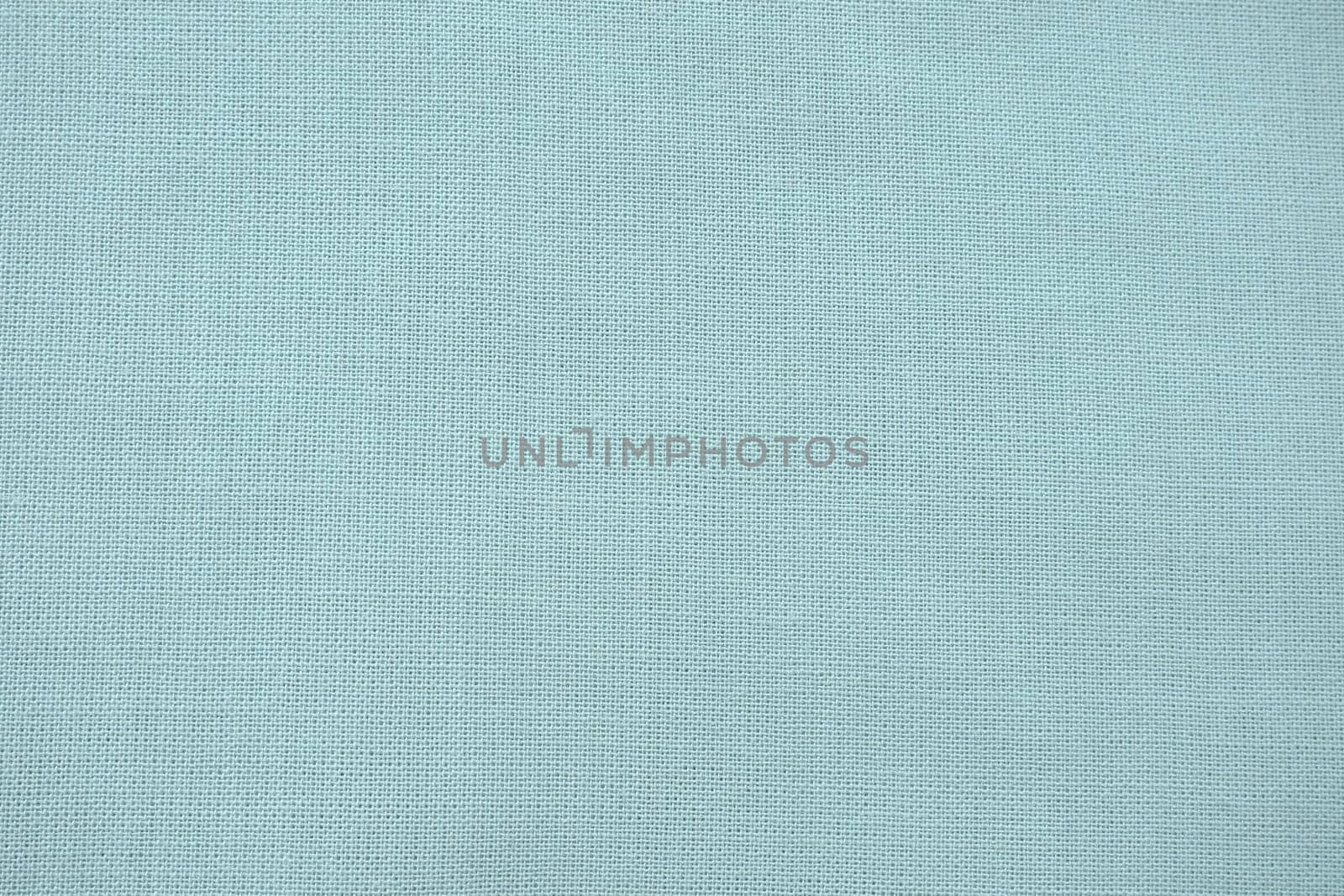 texture of natural light green or blue fabric close-up. The texture of the fabric is made of natural cotton or linen textile material. Green canvas background. Smooth surface of mint-colored fabric.