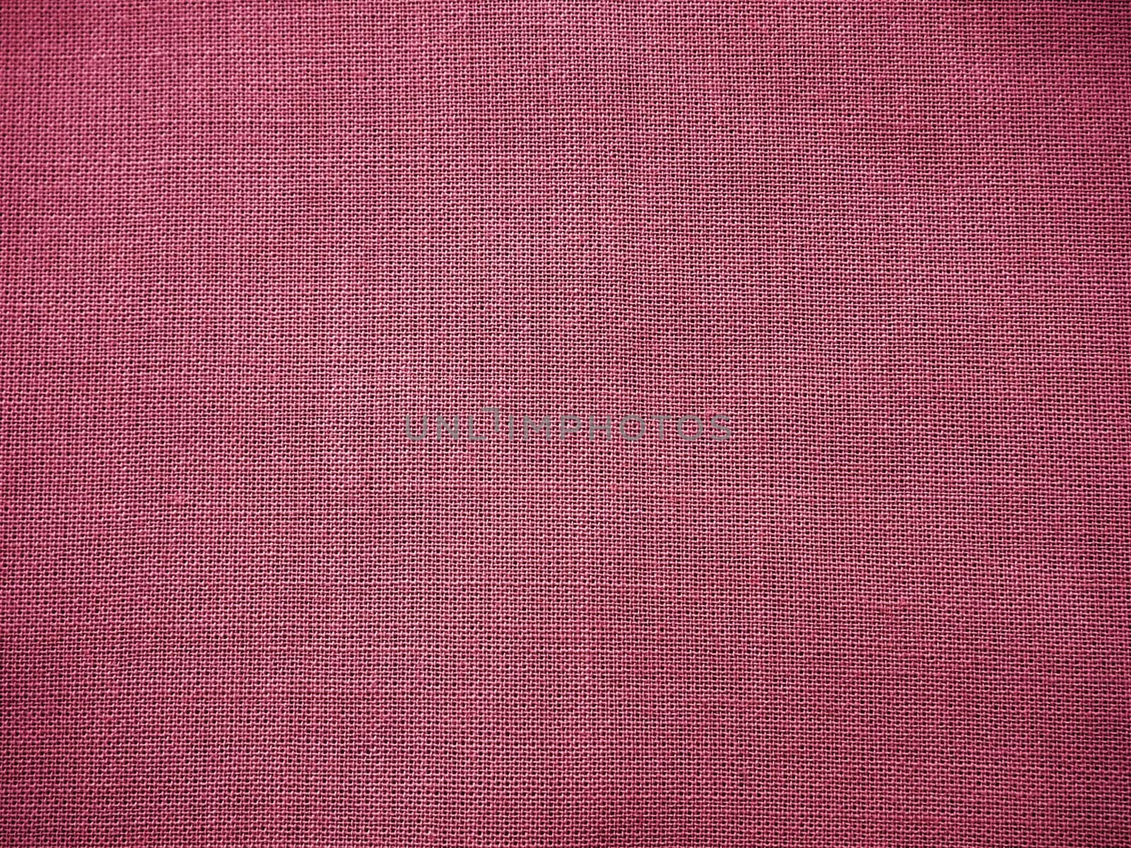 Cloth close-up. Interlacing of threads. A piece of pink fabric. Fabric background. Copy space.