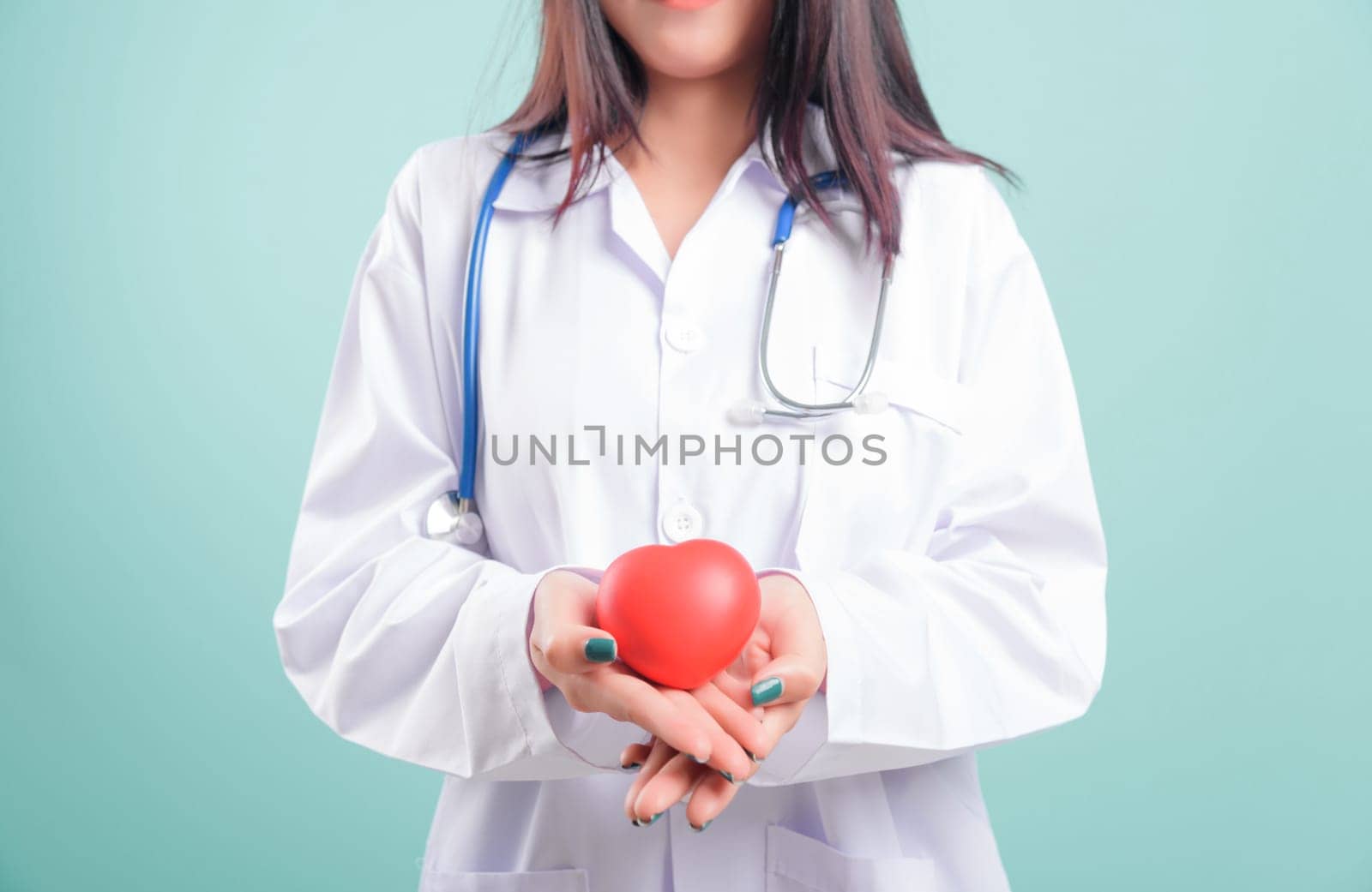 Doctor Day, beautiful nurse young woman smiling with doctor stethoscope holding red head on hand isolated on blue background with copy space, Medical healthcare staff service concept
