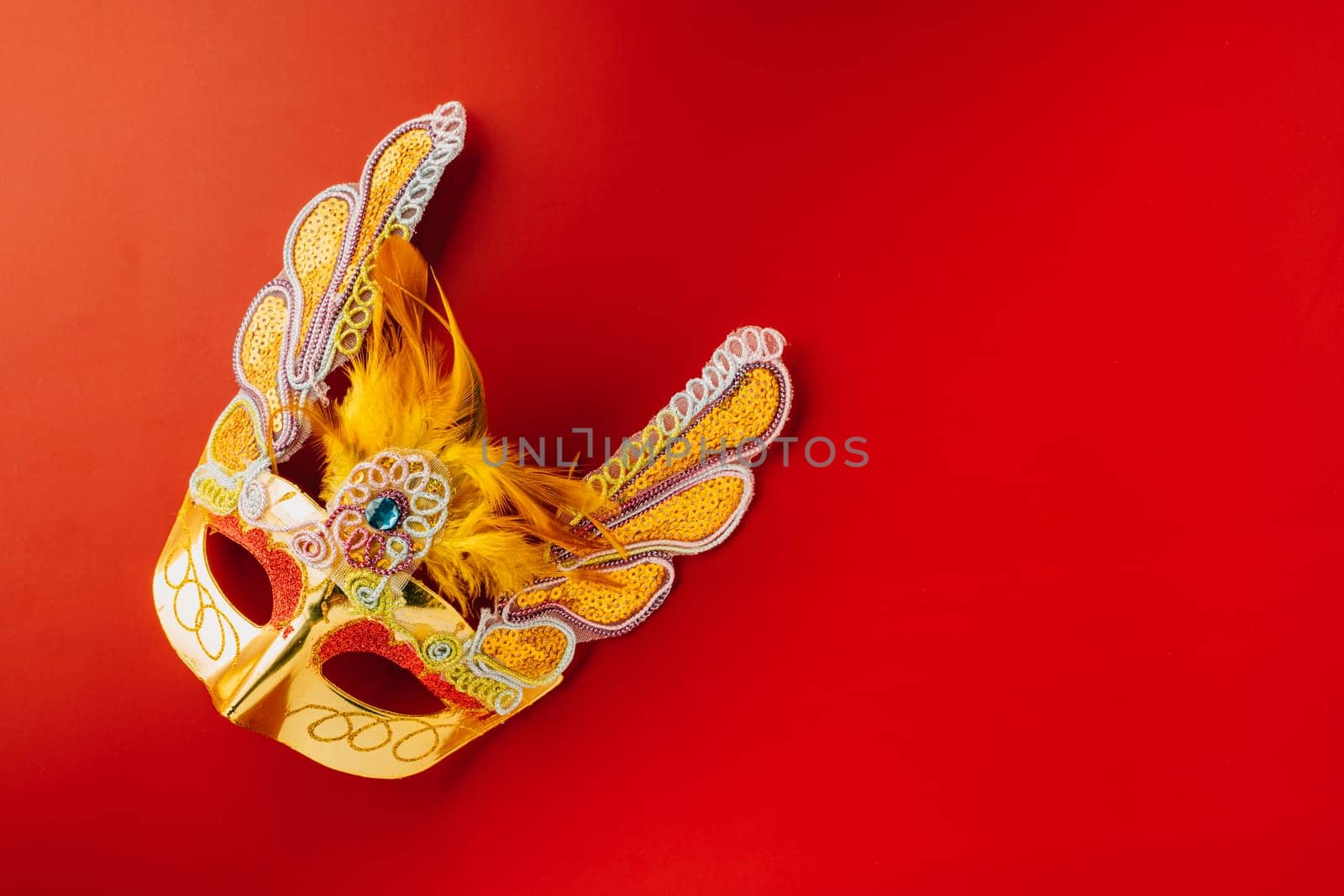 Happy Purim carnival. Carnival mask for Mardi Gras celebration isolated on red background banner design with copy space, jewish holiday, Purim in Hebrew holiday carnival ball, Venetian mask