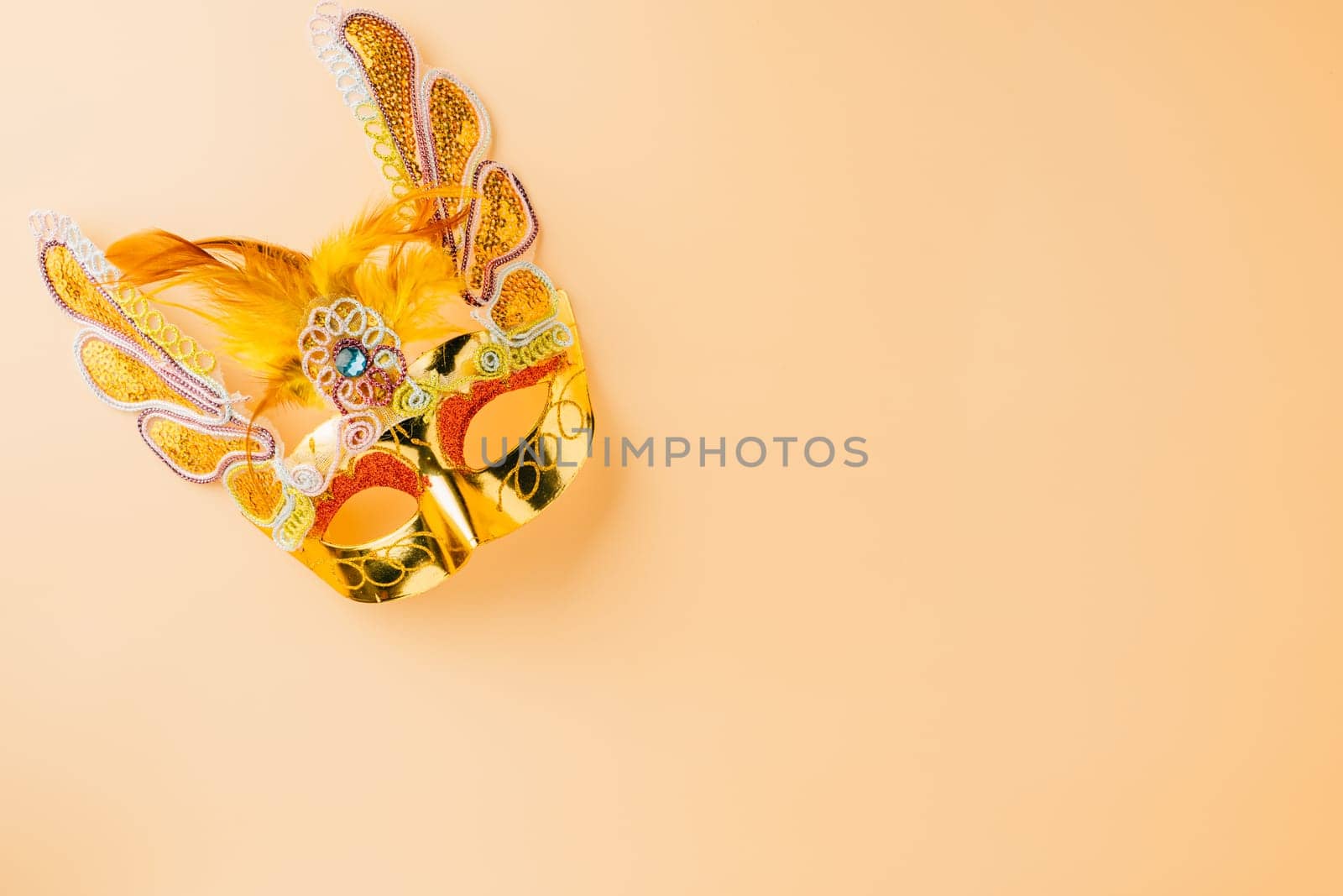 Happy Purim carnival decoration. Golden venetian ball mask isolated on pastel background, Jewish Purim and Mardi Gras in Hebrew, holiday background banner design with copy space, Masquerade party