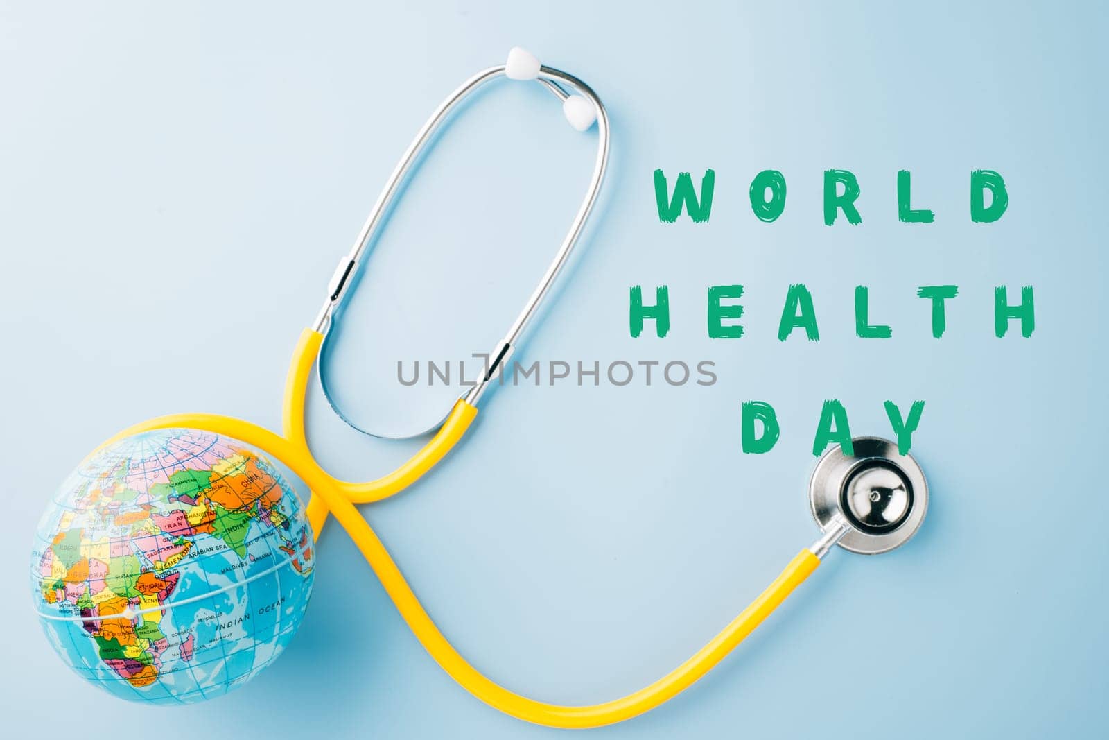 World Health Day. Yellow doctor stethoscope and world globe isolated on blue background, Save world day, Green Earth, Healthcare and medical concept