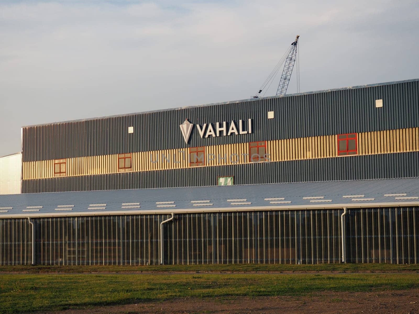 Zasavica, Machvanska Mitrovica, Serbia April 30, 2021. VAHALI shipyard and ship repair yard. Industrial building. View from the street at the golden hour. Due to VAHALI crane.