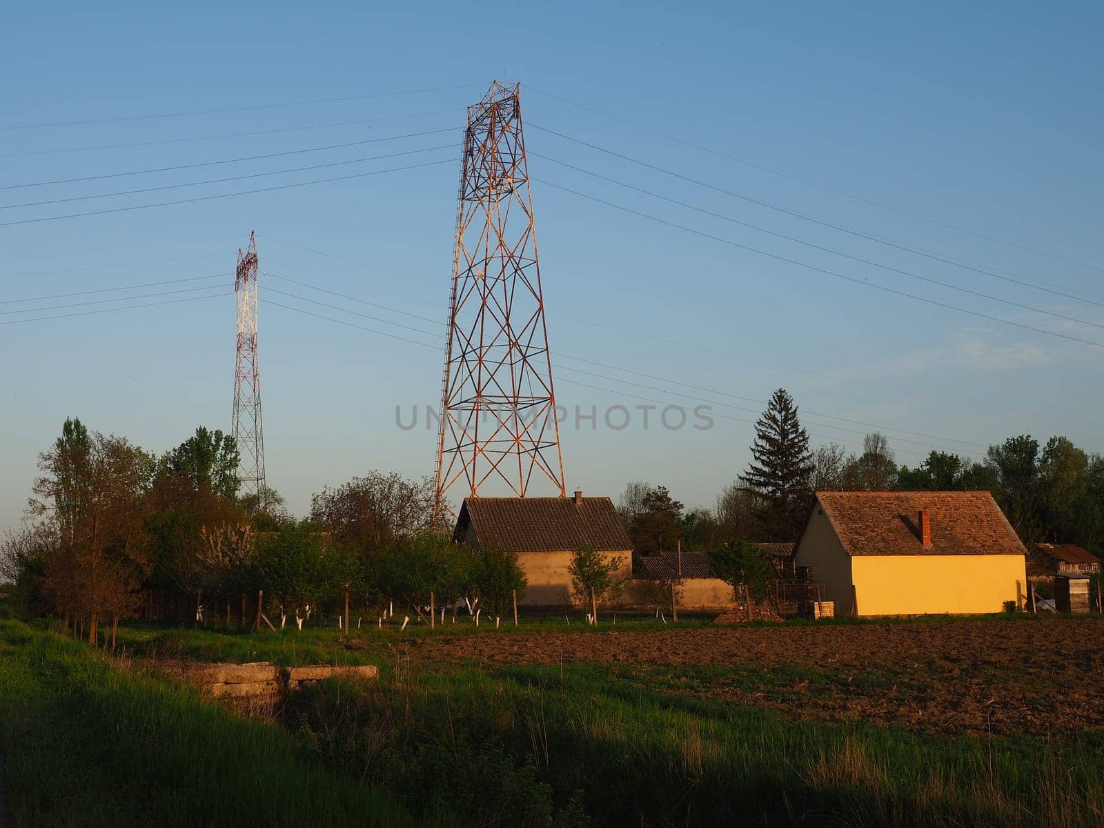 House and arable land next to the power line. Electrical network, power equipment system for the transmission of electricity by means of electric current. Negative effect of electromagnetic radiation.