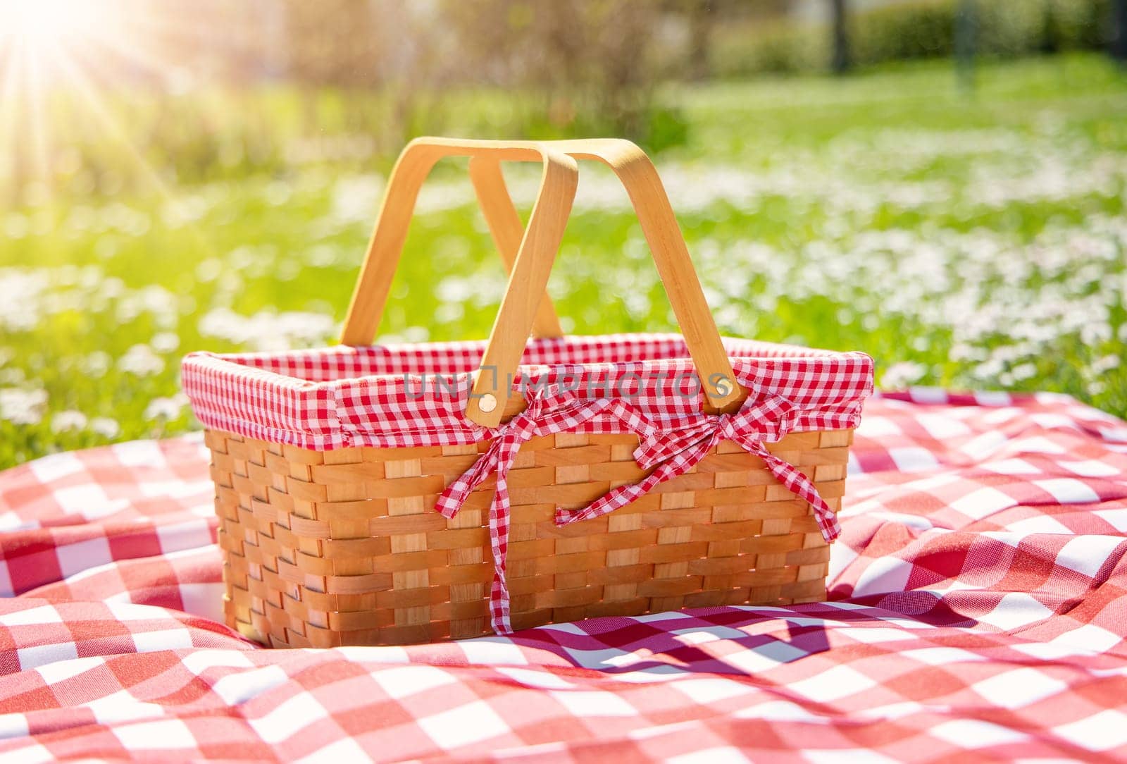 Picnic duvet with empty basket on the meadow in nature. Concept of leisure and family weekend.