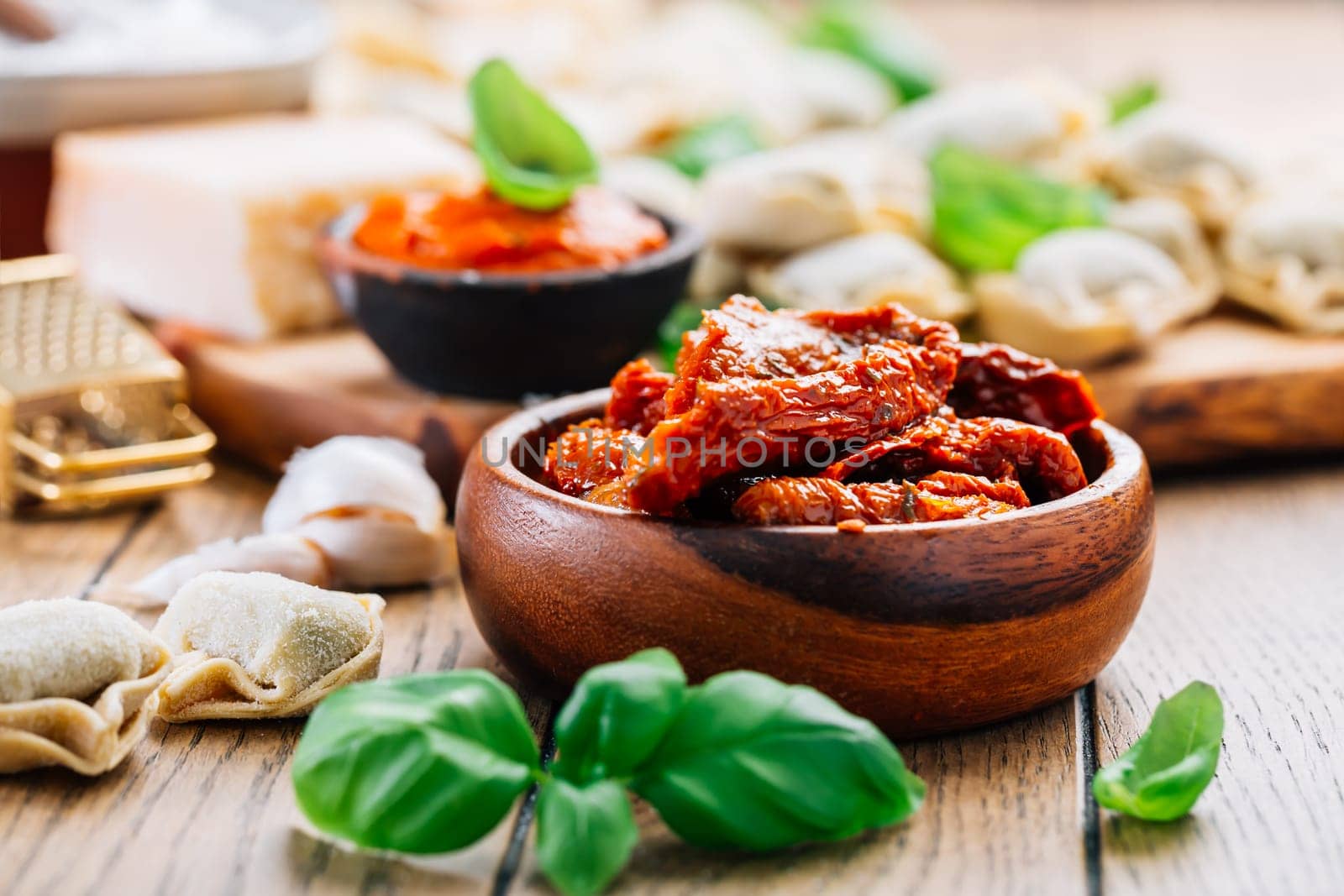 Home cooking - raw tortellini pasta with tomato pesto and sun-dried tomatoes and basil