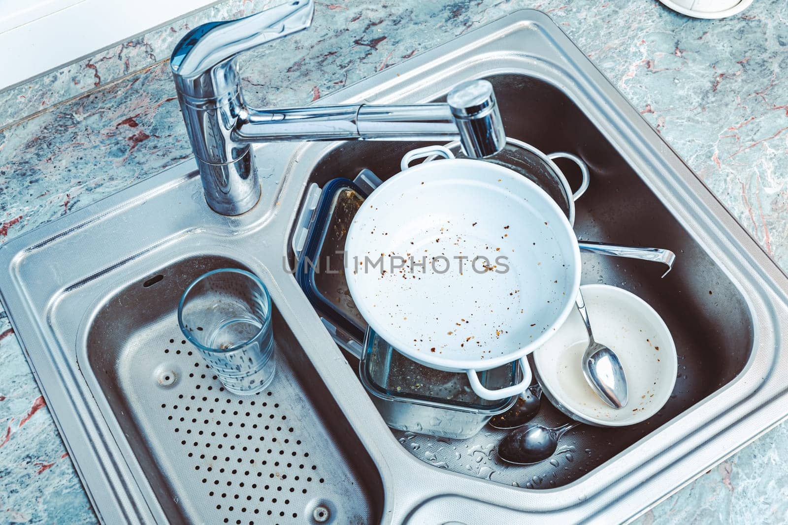 Dishwashing - pile of dirty dishes in kitchen sink