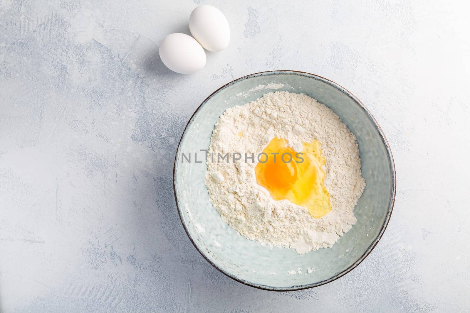 Flour with egg in bowl - cooking and baking ingredients