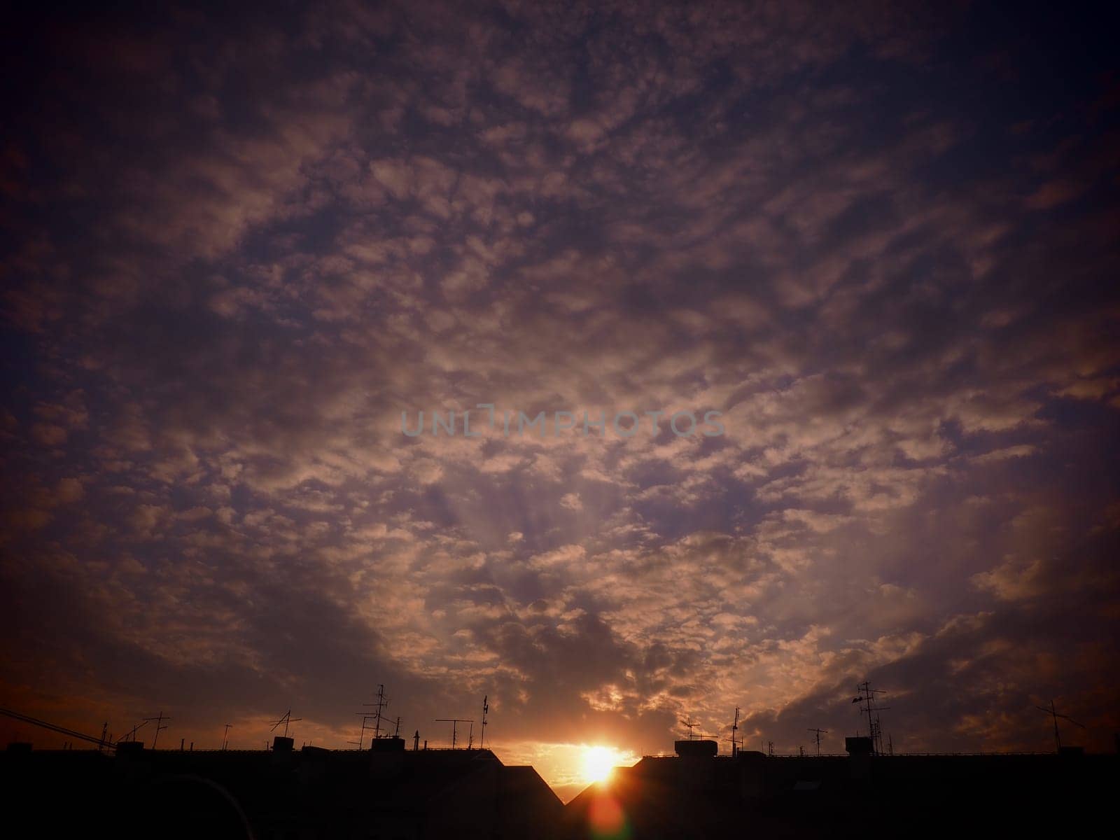 Pink, red, purple sunset sky cloud. Dramatic sunset sky. Wonderful sunset. Clouds in the evening sky. The sun's rays pierce the clouds. Beautiful landscape. The sun goes down.