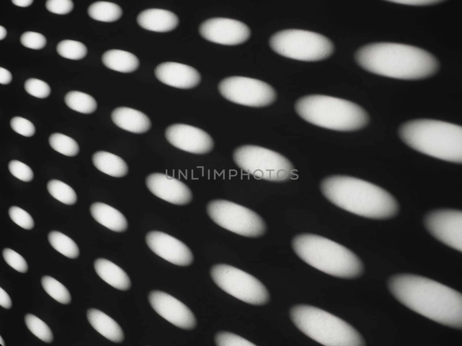 abstract sun bunnies ovals. Black and white trendy ugly. Retro or disco style. Abstract background with different blurred sun glare passing through the holes of the blinds or shutters.