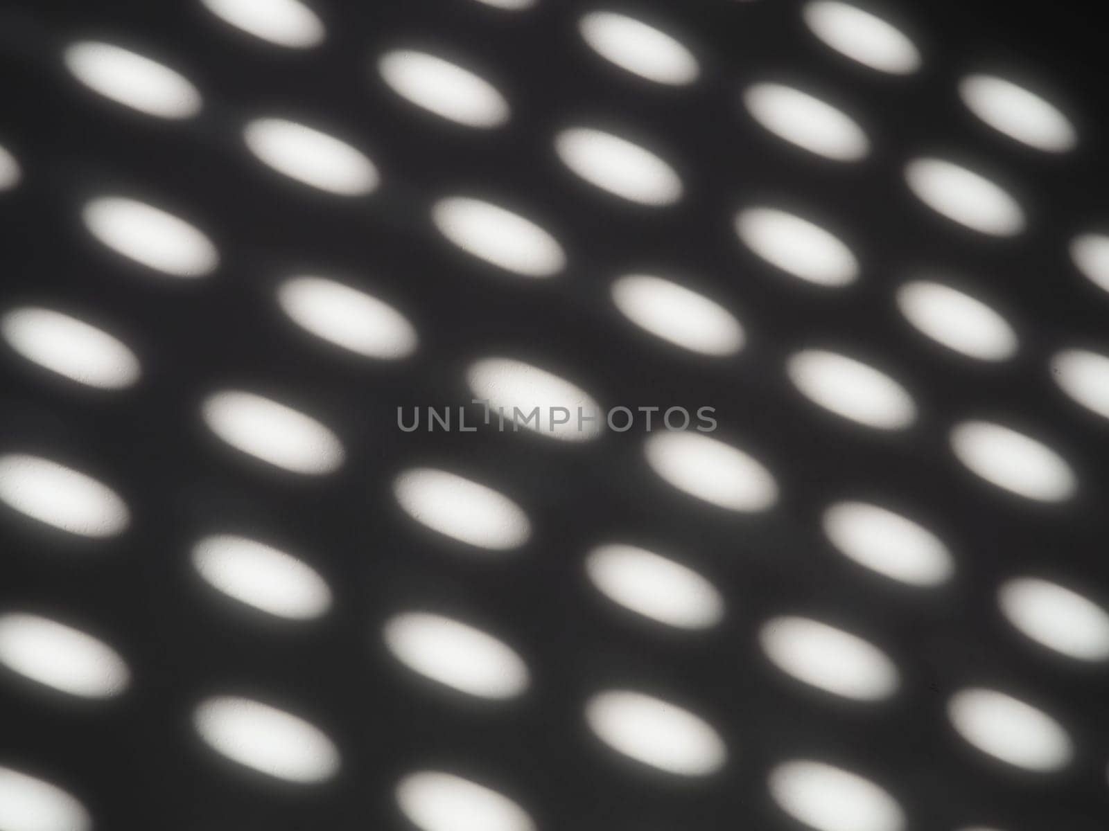 abstract sun bunnies, dots and ovals on gray background. Retro disco style. Abstract backdrop with different blurred sun glare passing through the holes of the blinds or shutters.