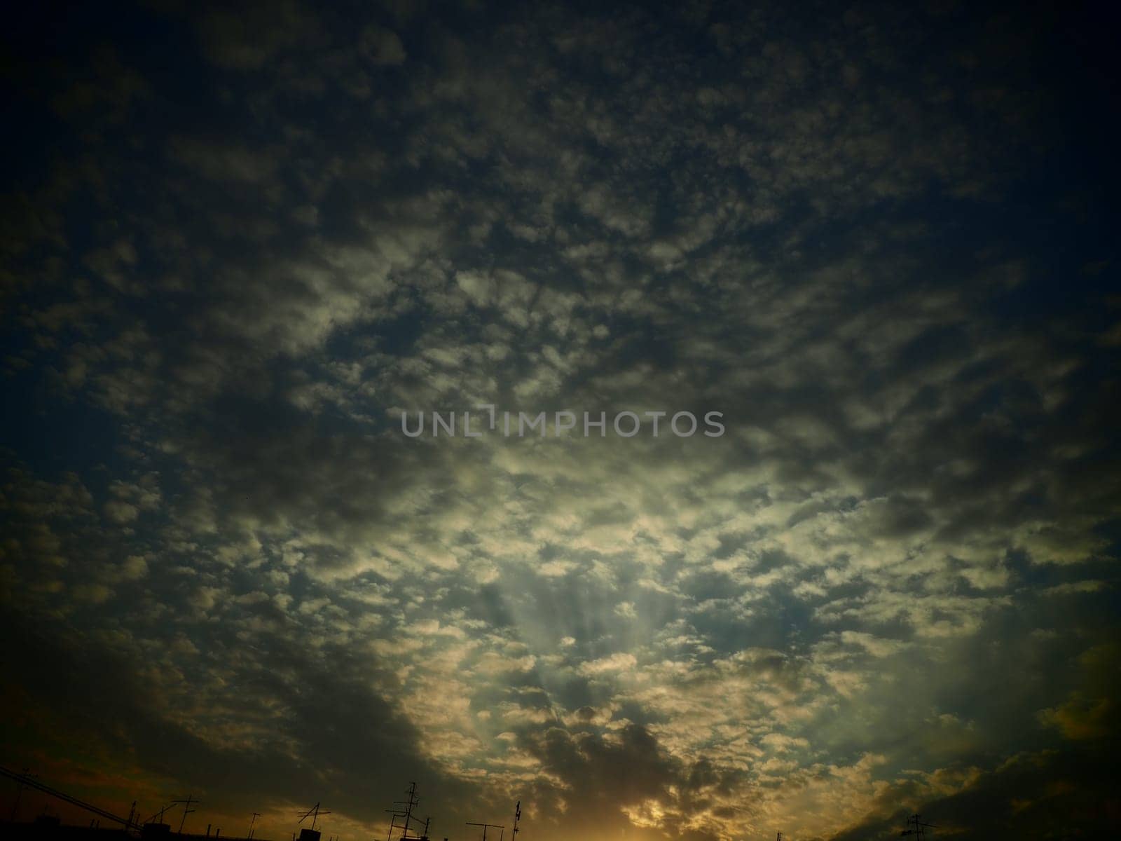 Black, green and yellow sunset sky cloud. Dramatic sunset sky. Wonderful sunset. Clouds in the evening sky. The sun's rays pierce the clouds. Beautiful landscape. The sun goes down. Vignetting