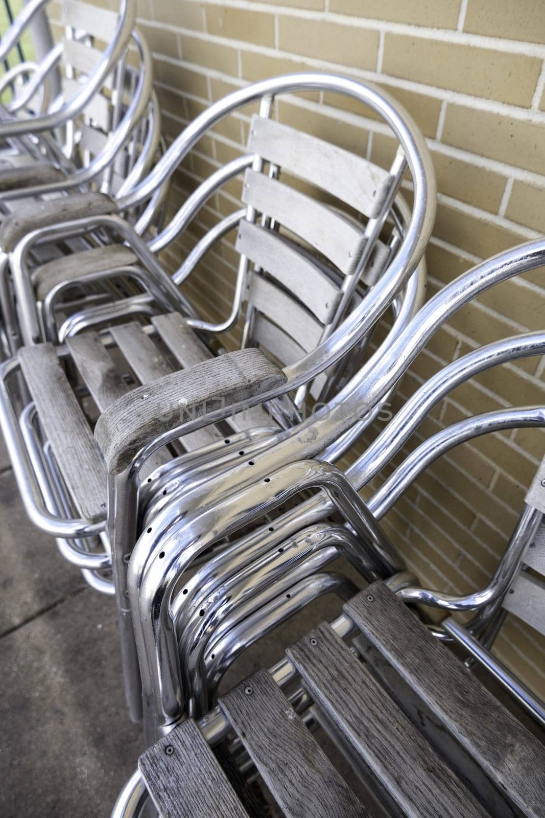 Detail of shiny metal chairs on a terrace of a bar in the city