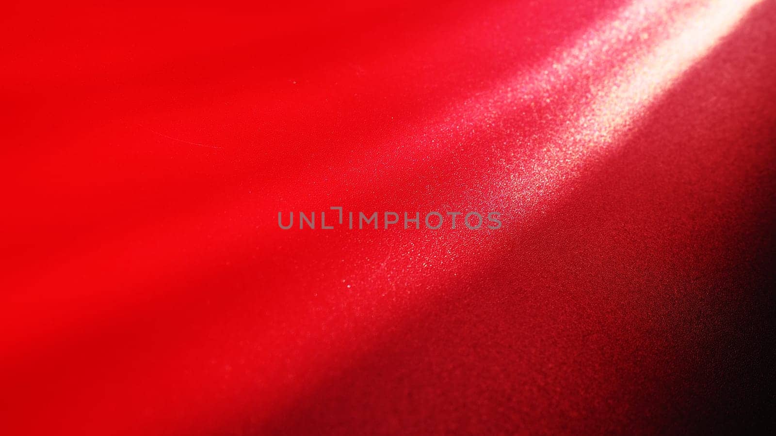 Diagonal rays of light on a red or scarlet background. Blurred abstract background light effect, light leaks. Side surface illumination. Parallel and asymmetric lines or stripes of light at an angle