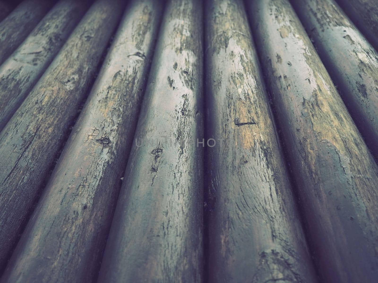 A construction log for use in construction without longitudinal sawing. Round timber assortment. Fragment of the construction of rounded wooden logs. The effect of moisture on wood