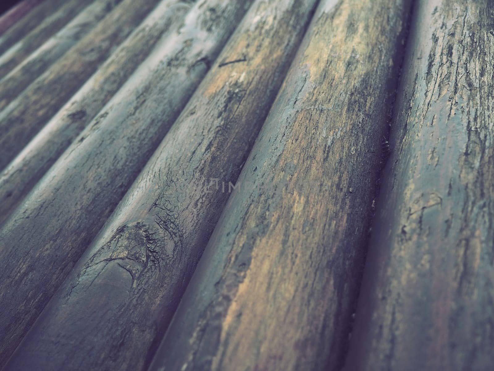 A construction log for use in construction without longitudinal sawing. Round timber assortment. Fragment of the construction of rounded wooden logs. The effect of moisture on wood