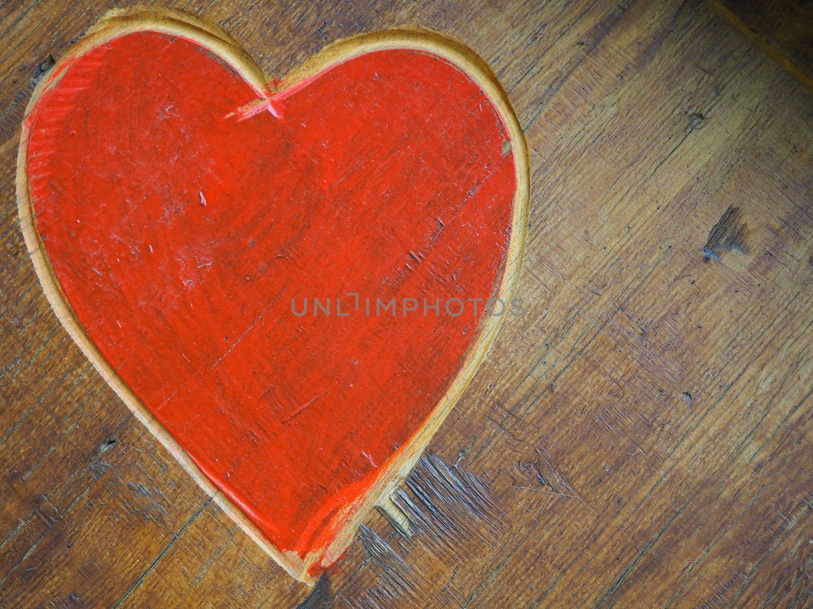 The shape of a heart carved with a knife on a wooden surface and painted in a bright red. A symbol of love and fidelity. Postcard or picture for congratulations or confessions on Valentines Day