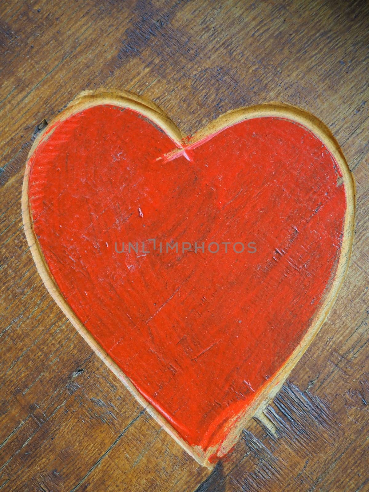 The shape of a heart carved with a knife on a wooden surface and painted in a bright red. A symbol of love and fidelity. Postcard or picture for congratulations or confessions on Valentines Day