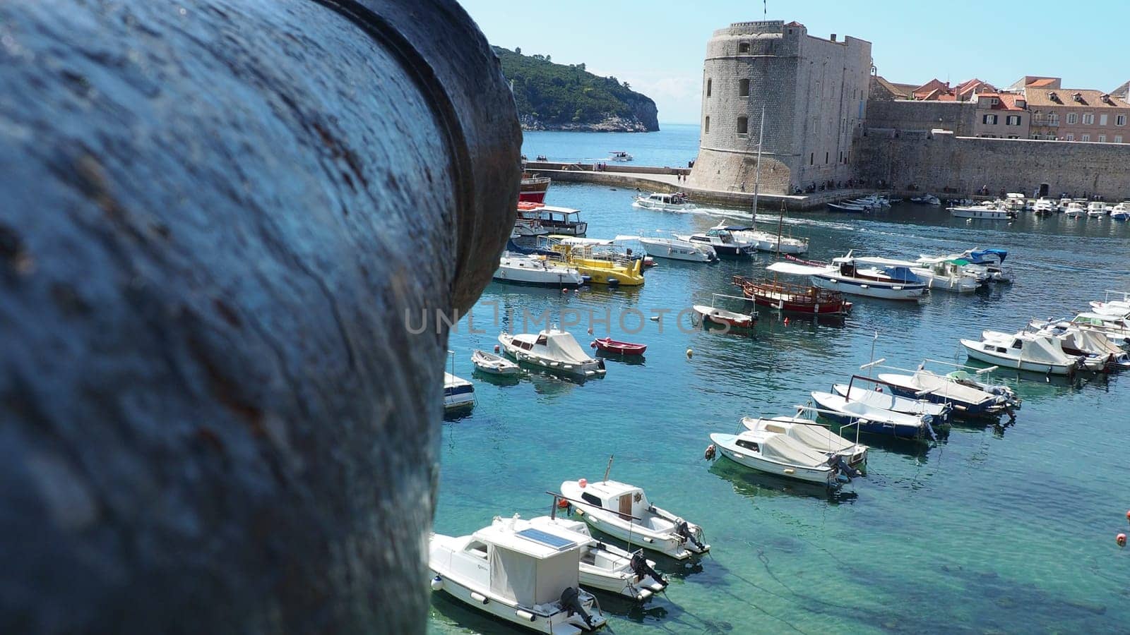 Dubrovnik, Croatia, 08.14. 2022 City port summer tourist attraction. Tourists walk, get into boats and ships and go on boat trips. Adriatic Sea. Travel. Cannon muzzle. Private boats of local citizens
