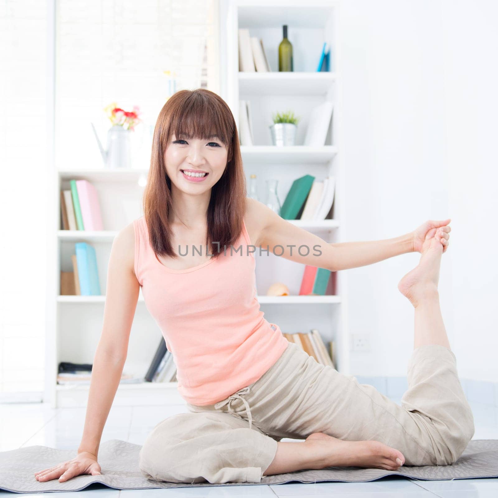 Happy Asian girl stretching and yoga in the morning. Young woman indoors living lifestyle at home.