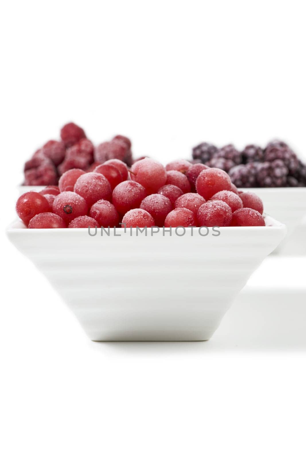 Three bowls of different frozen berries