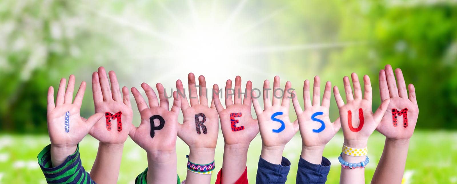 Children Hands Building Colorful German Word Impressum Means Imprint. Sunny Green Grass Meadow As Background.