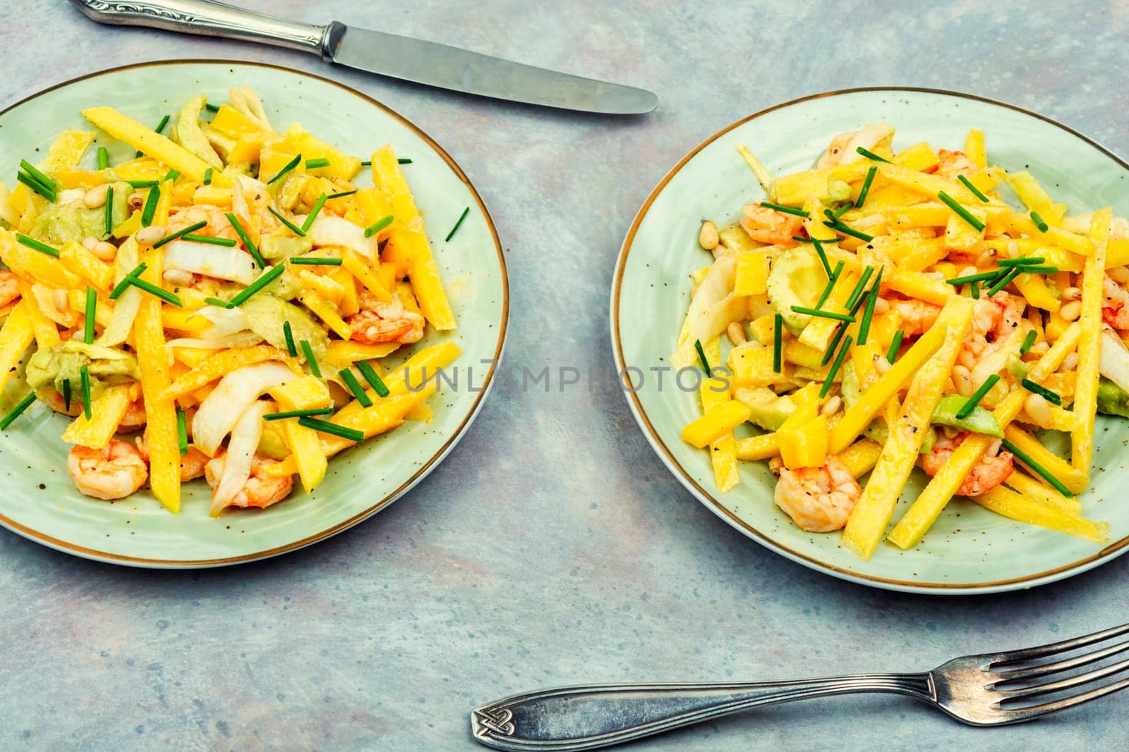 Delicious salad of mango, avocado, shrimp and pine nuts. Food background